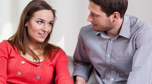 Een vrouw en een man in gesprek op een bank